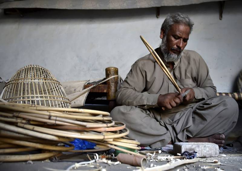 پشاور، کاریگر ہاتھ سے بنے پرندوں کے پنجرے بنا نے میں مصروف